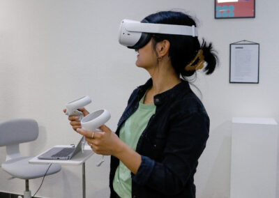 Kunstprojekte von Studierenden, die mit Hilfe von VR Brillen erlebbar gemacht wurden. Person wendet VR Brille an
